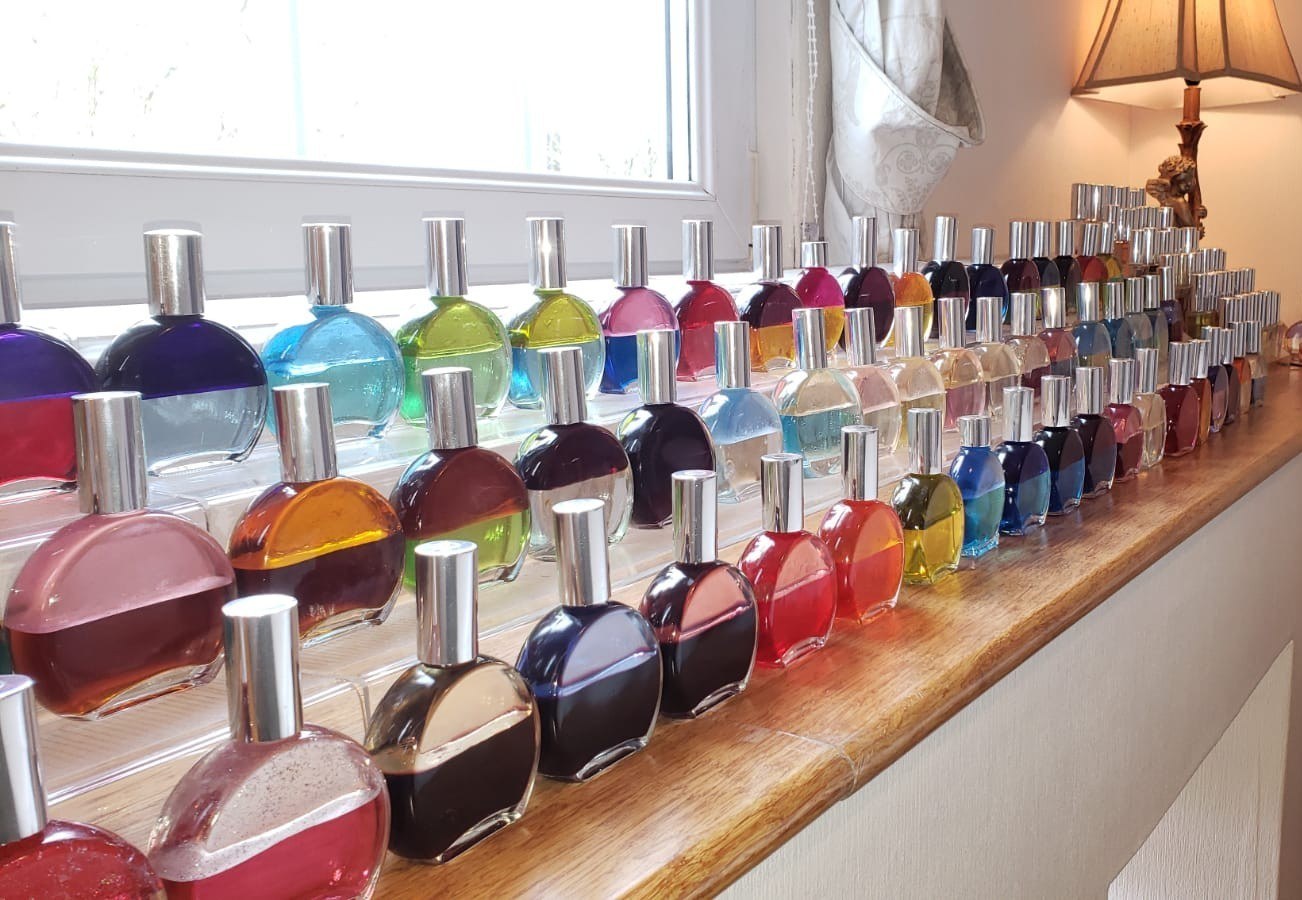 Rows of Colour Mirrors bottles along a sunlit windowsill